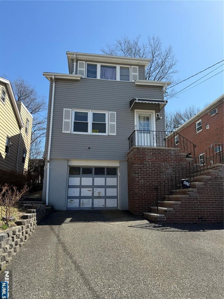 This two-family house offers substantial potential, featuring a one-car garage and ample ground-level storage. The first floor boasts two bedrooms, a kitchen, a complete bathroom, and a living room. The second floor includes a living room, a kitchen, a complete bathroom, and a bedroom. The rooms are generously sized, and each unit is equipped with its own separate electrical meter. The property is being sold as is. Buyer is responsible for any required certificate from town.