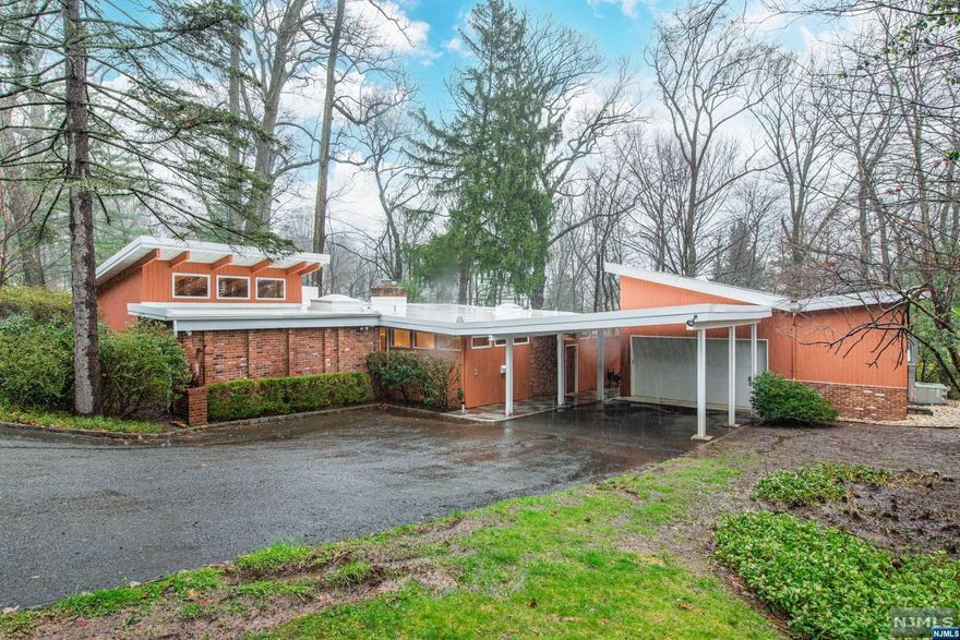 Stunning mid-century modern gem in desirable Gregory neighborhood, near schools, shops, NYC transport & more! On wooded lot off private dead-end road, this 3-BR, 2-bth home w heated 2-car garage blends classic mid-century design w modern comforts! Open floor plan, natural light, wood panels, cedar ceilings, stone foyer. LR w beamed ceiling, brick FP, clerestory & fl-to-ceiling windows, HW fls, sliders to patio & open access to kitchen. Kitchen w custom cabs, skylight & mudrm w W/D, sink & backyard access. 3 BRS & 2 full bths tucked away from main living space. BR 1 w fl-to-ceiling windows & sliders to patio, recessed & track lights, clerestory windows & beam ceiling. Landing off LR leads to full bth, linen closet & BR 2 w builtins & clerestory windows. Guest closet & huge primary BR suite w closets, wood beams, vaulted ceiling, builtins & sliders to backyard. Ensuite bth w soaking tub, shower, double sinks, skylight.Basement w storage & utility rm; garage w heat/AC & patio access.