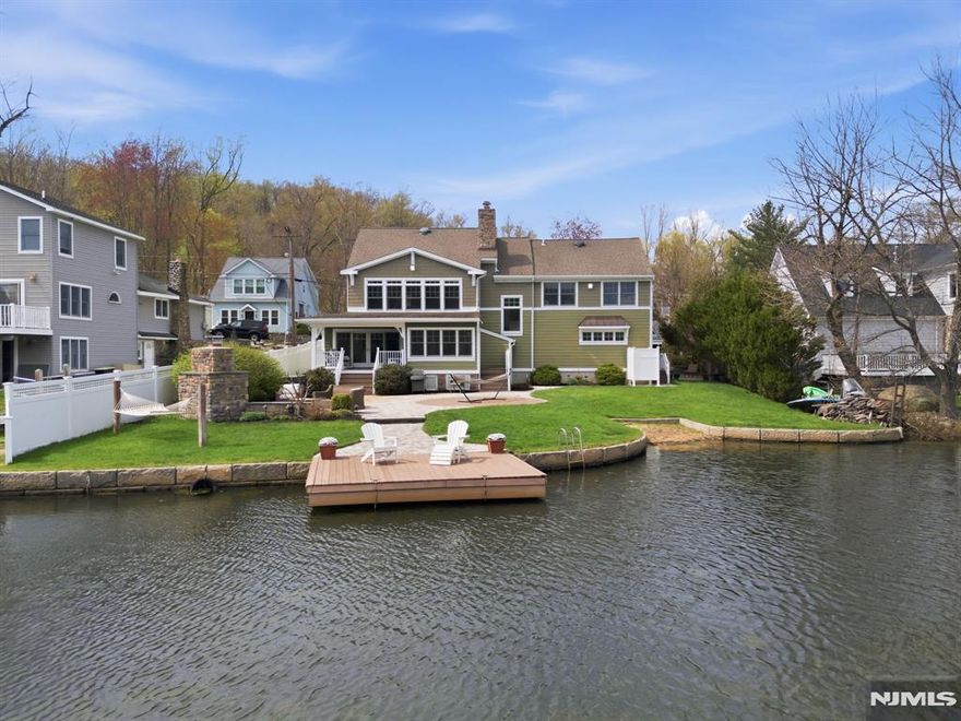 Absolutely stunning lakefront Craftsman style Colonial on one of the most desirable & few double lots on Indian Lake, offering panoramic water views & timeless design. 6 BDRM / 3.5 BATH TOTAL. Open concept main level with hand scraped HW floors, a striking stone fireplace & a sunroom with cedar plank-style ceiling extending the living space with full lake views. Classic kitchen with granite, shaker cabinetry, SS appliances & walk-in pantry. Dining room with double sliders seamlessly connects to the outdoors, perfect for Summer entertaining. Incredible family room currently set as a pub style room with coffered wood ceilings, stone wall facade, raised booth seating & full wet bar. Upstairs features 5 bdrms & 2 full baths, including a primary suite with high ceilings & 2 walk in closets. The walk up attic offers expansion potential. Smart recent updates include french drains & natural gas generator which adds peace of mind. Resort style exterior with private beach, dock, patio, fireplace, hot tub, outdoor shower & lawn for games & relaxation. Fenced in for privacy. Bonus 1BR/1BA apartment over 2 car garage with private entrance, parking & meters ideal for guests or rental income. Enjoy everything the ILCC community has to offer, including a clubhouse, 3 beaches & motorboat friendly waters. With year round activities for all ages, from boating, swimming & fishing to ice skating, this is more than a home, it's a lifestyle. Minutes to DWTN Denville, NYC transit & major highways.