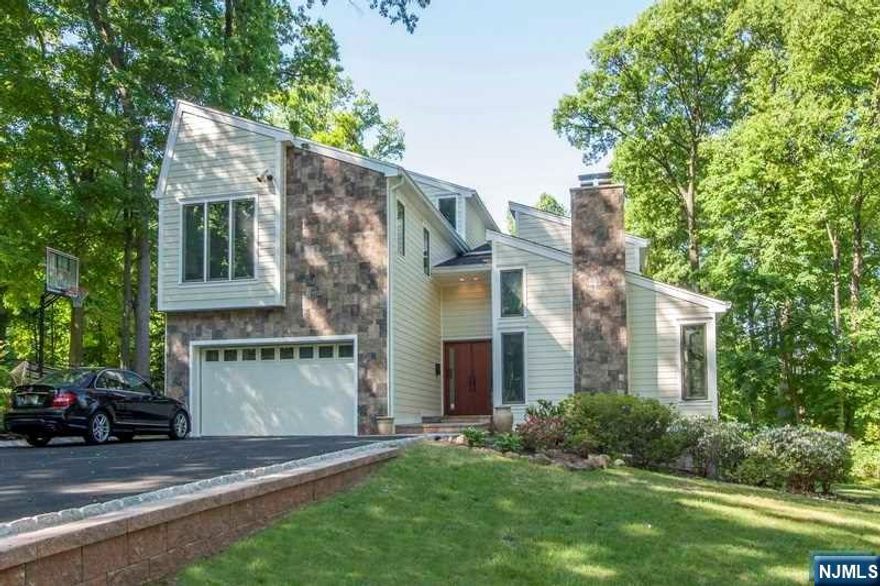 Prime East Hill Tenafly location!! Enjoying living in a private approximately 0.506-acre Center Hall Colonial with contemporary flair. This spacious and totally renovated 5-bedroom 3.5 bath home has a heated 20 x 60 Gunite pool and spa! Lovely home that offers an open floor plan with a dramatic two-story entry foyer leading into a two-story formal living room with fireplace, dining room, custom gourmet kitchen, family room with fireplace and convenient powder room. Hardwood flooring throughout, oversized two car attached garage, third floor finished loft perfect for guests, finished basement with 5th bedroom and full bath, and newer hardi-plank exterior. Second floor offers primary bedroom suite with walk in closet and luxury bathroom and three additional bedrooms and full bathroom. Plenty of closet space and storage space. Five zone heat, three zone central AC, alarm system, lawn sprinklers, beautiful deck, paver patio blue ribbon schools. This home is not to be missed!