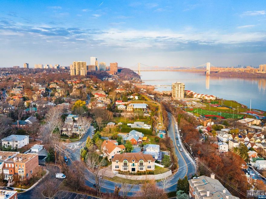 For more info contact Kim Damion 240-620-5811. Indulge in the luxurious elegance of this custom-built center hall colonial in the sought-after Bluff section of Fort Lee w/ breathtaking views of NYC. With 5317 sq ft of exquisite craftsmanship this home is a testament to the work of old-world artisans combined w/ today's sophisticated techniques. A blend of traditional & modern styles, desirable amenities, custom moldings& high ceilings. Enter the 2-story foyer w/ double staircase& appreciate the hardwood flr LR&DR, den w/ mahogany inlays& sunlit great rm w/ exquisite architectural details. Gourmet kit w/ custom cabinets, SS appliances, island, pantry& heated floors like the foyer. Primary BR suite w/ NYC views, luxurious PBath/soaking tub, walk-in closet. 4 additional sunlit ensuites w/ high ceilings& laundry rm complete upper lev. Fully finished basement is an entertainer's delight- BR, FB, exercise rm, entertainment rm, storage. Elevator space has been made for easy installation!