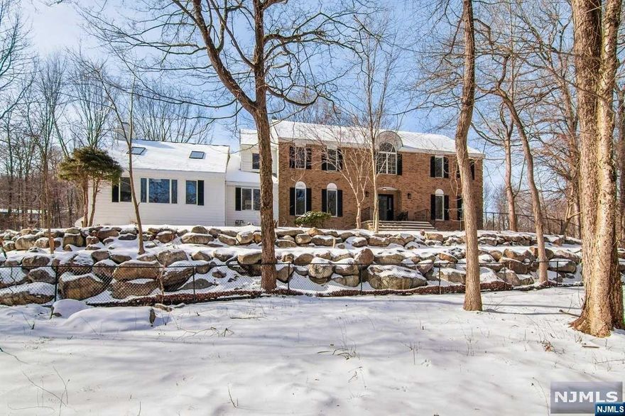 Welcome to your dream home in the prestigious Saw Mill neighborhood of Kinnelon.This completely renovated 5 bedroom,3 1/2 bath residence sits on 4.6 tranquil acres where you can enjoy the sounds of nature in complete privacy. Spanning an impressive 4,200 sqft, this home welcomes you with a two story entrance that sets the tone for the beautiful flow throughout. The expansive living spaces on the first floor feature an abundance of natural light, creating an inviting atmosphere that is both warm and sophisticated. The sweeping two story living room is punctuated by a cozy wood burning fireplace. The kitchen boasts stainless steel appliances, white quartz, custom cabinetry with gold hardware and fixtures. The layout effortlessly flows into the formal dining area, making it perfect for entertaining.