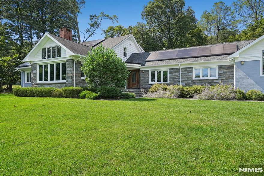 Absolutely stunning, this fully renovated 6-bedroom, 5 full and 2 half bath raised ranch is perched on a hilltop and drenched in natural light, offering tranquility, relaxation, and a seamless connection to nature where everyday living feels like a vacation. The open layout connects expansive living spaces including outdoors, ideal for today's work-from-home lifestyle, This smart home features two solar rooftop systems, all new double-pane windows, and energy-conscious upgrades. The outdoor oasis is unmatched, with a heated in-ground pool, fully equipped pool house with kitchen and full bath, and bluestone patios perfect for dining, lounging, and outdoor movie nights.The formal yet inviting living room showcases dramatic architectural detail, a wall of windows capturing sunrise and NYC skyline sunset views Plans are available for the 3,100 SF basement, where walls, French drains, and five sump pumps are already in place. At the heart of the home is the chef's kitchen and family room, featuring custom Spanish cabinetry, high-end appliances, and a 15' x 6' island with prep sink, wine cooler, and seating for six, plus a separate dining area. A 1st fl laundry rm off the mudroom 3 distinct sleeping/work zones provide flexibility: A 1st fl primary suite w/ fireplace, dressing room, walk-in closet, & bath, plus a 1st fl bedroom w/bath a 2nd-fl south wing - 3 bedrooms and hall bath; a private north wing studio bedroom with its own staircase, bath, and sink. A garage w/ EV charger.