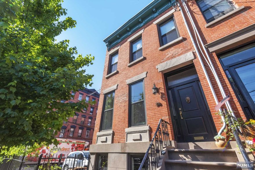 Welcome home to this designer 3 BR 3 BA showcase town house in desirable midtown Hoboken with a corner lot location and one deeded adjacent parking spot. This home, featured in Better Homes and Gardens was completely and tastefully gut renovated with a brand new top floor bathroom just completed. Custom designed cabinetry, honed Carrara marble countertops, concealed designer appliances, built -in banquette storage replete with two working fireplaces. An added full bath with Ming green and Carrara marble also graces the parlor floor. Exposed brick, re-built staircase, restored original moldings, new concrete garden level floor with an added bedroom, and new full bath and laundry room. Designer wall paper and carpeting throughout, new doors, new hardware and new windows throughout, customized closets, and potential future roof deck complete this home. Other upgrades include two zone heating and cooling UNICCO system, updated electrical and gas lines, and a newer roof.