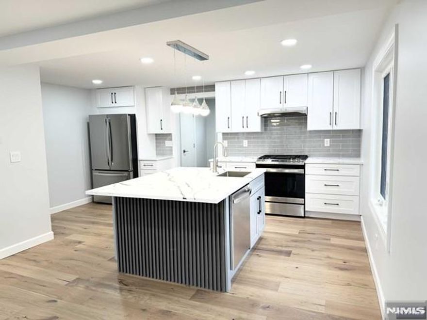 Welcome to your dream duplex-style apartment with top-notch finishes. Step into the spacious open-concept living room and gourmet eat-in kitchen with an island, stainless steel appliances, and gleaming quartz countertops. You will also find a coat closet and powder room on this first floor. Upstairs, you will find two bedrooms, one full bathroom, and pull-down stairs for storage in the attic. On the ground floor, you will find a fully finished basement with hook-ups for a washer and dryer. Forced hot air and central air with two separate units. This location is perfect for commuters, with the NJ Transit Train station right across the street. Additionally, you'll have the convenience of two parking spaces.