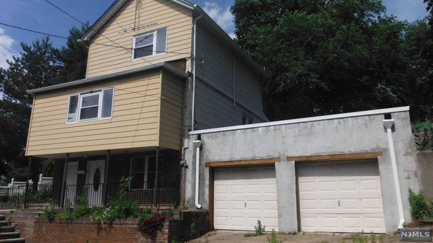 OVER sized two car garage, and parking spaces on the other side of the house. Lot is irregular shaped and terraced with three levels of living space. Large bedrooms and plenty of potential. Easy walk to local shopping and schools.