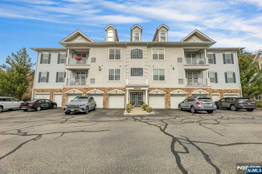 Welcome to 4 Seasons at Great Notch, a vibrant 55+ gated community! "Magnolia" 2-bedroom, 2 bath unit located on the 2nd floor in an elevatored building with a fabulous view of Rifle Camp Park off the balcony! This well-kept home has approx 1,750 sq ft of living space, a built-in private 1-car garage with storage room and parking space! Living/Dining room combo with gas fireplace and door leading to a spacious balcony, gourmet kitchen with double oven, gas range, dishwasher, microwave & refrigerator. Granite counter tops, breakfast nook, spacious den, laundry room, 2 bedrooms & 2 tiled baths (Primary King-size bedroom has a walk-in closet, full bath with double sink, shower stall, and jetted soaking tub. Hardwood flooring in the living area, wall-to-wall carpet in bedrooms. Pet-friendly, maximum of 2 pets, no breed restrictions. Gas forced air heat, gas water heater, and central AC. Maintenance fee of $529 includes amenities such as: clubhouse with gym, indoor & outdoor pool, card room, ballroom, billiards, bocce, tennis & pickleball courts, putting green, and more! Conveniently located near major roads.