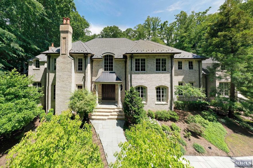 Fabulous sunset views and ultra-privacy at this west facing country manor on 2 acres. Approx. 7100 sf of living space PLUS a newly finished lower level with an outstanding open bar/kitchen area, wine cellar, media, and full bath. This home exudes extraordinary millwork, designer details, limestone and hardwood flooring, 4 masonry fireplaces, true divided light windows & superior quality. Living Room has a detailed coffered ceiling, banquet-sized dining room, butler's pantry, magnificent office, gourmet kitchen with seated center island, prof appliances, and a lovely breakfast room. A billiards/pub room & the soaring 2-story great room has a floor-to-ceiling stone fireplace, stunning architectural windows & French doors leading to the patios. First floor en-suite bedroom & 4 en-suite bedrooms upstairs include the large primary suite, bonus room & laundry. The stunning backyard is outlined with terraced stone walls, perennial gardens & patio for alfresco dining.