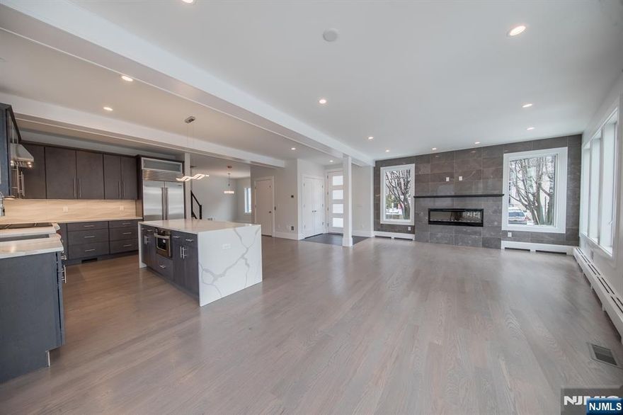 This stunning contemporary smart home was completed in 2018 with sleek interiors and state of the art appliances. It is a 4 story, corner lot townhome, that has a private elevator and enclosed fenced yard. Great open floor plan and feel that gets lots of natural light. The Lutron lighting system, motorized windows and blinds, modern fireplace and unique layout all make this home one of a kind. The Master bedroom features luxurious spa ensuite with multi-head rain shower, radiant heat, steam shower and free standing tub. Magnificent views of the Hudson River and NY skyline await on the top floor which features a den, custom built-in cabinets, a wet bar, half bath and an exquisite rooftop deck with enclosed railings for safety. The cheerful east facing kitchen has a large center island with white Quartz waterfall countertop, & Porcelanosa backsplash. It also has stainless steel appliances w/a 36" inch Wolf Range, Sub Zero Fridge, & a large stainless steel farm sink. Great for entertaining from the den or movie room below, spacious main level, to the incredible roof deck above. This home is conveniently located in the central Edgewater location and is just steps away to a playground, Montessori school, library, and Whole Foods. Also close to bus & ferry transportation to NYC.
