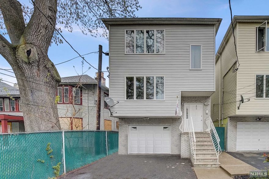 Welcome home to your turnkey 2-family with a bonus unit in a prime location! This home features two identical 3BR/2BA units with open concept living/dining with hardwood floor throughout, large kitchen with tons of storage space, two nice sized bedrooms, and full primary suite with en-suite bathroom and balcony off of the back with views of the NYC skyline from the top unit! Fully finished basement with 1BR, kitchenette, full bath, and walk-out access to a nice sized yard with plenty of room for summer BBQ's or an in-ground pool! This home has 2 complete laundry hookups in the ground floor hallway, attached oversized 1 car garage, and ample parking in driveway. Steps from transportation, parks, shopping, and dining - perfect for investors or owner occupants alike!