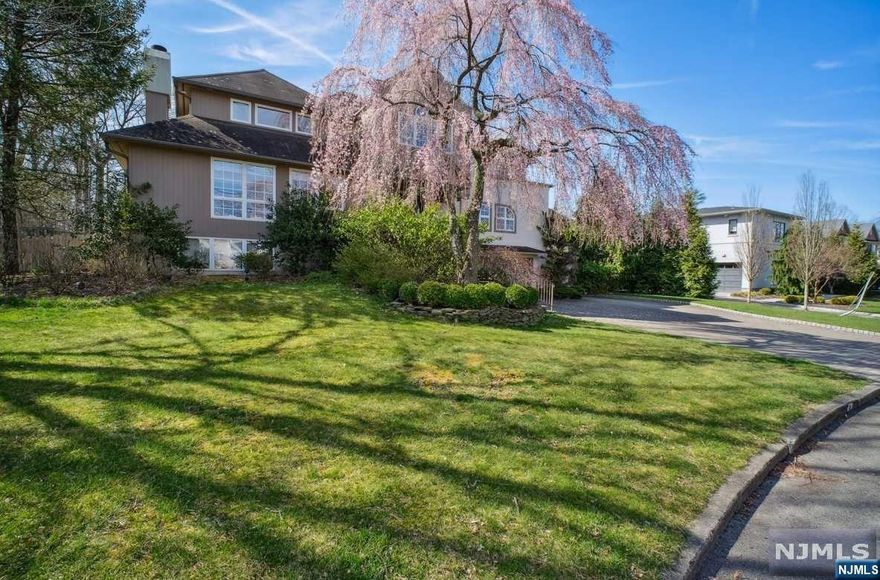 In the distinguished North Cliffs section of Englewood Cliffs, this custom-built contemporary home unfolds over two stories, showcasing an open layout. The 1st floor features a light-filled living room and a gourmet kitchen that transitions into a sunroom, revealing sweeping views of a backyard paradise (which includes an inground pool, multi level decks, a patio, & basketball court), and a private in-law suite with a fireplace-adorned living area. Upstairs, there are 3 bedrooms, with the master boasting a balcony and a spa-like bathroom. The basement offers two bedrooms, an office, a recreational area, another family room, and a summer kitchen, ideal for gatherings. Additional amenities include a three-car garage and a paver driveway, all while enjoying low property taxes. Its location is perfect, just minutes from the George Washington Bridge, Allison Park, and Flat Rock Brook, blending convenience with natural charm.
