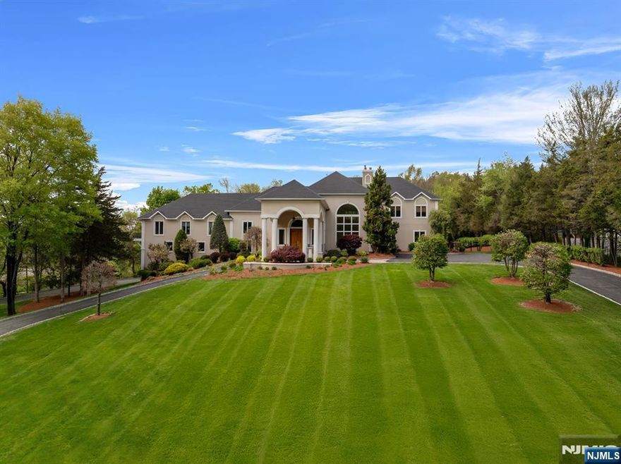 Welcome to a masterpiece of luxury 8,000+ square feet of pure architectural brilliance. Behind a gated entrance, a grand circular driveway and a stately portico set the stage for what is truly a one-of-a-kind estate. Step through the soaring two-story foyer, where travertine floors gleam under the light of handcrafted Murano glass chandeliers from Italy. The sunken living room is the crown jewel of this estate, a space designed to captivate from the moment you step inside. A majestic wood-burning fireplace completes the scene and stands as both a statement piece blending luxury with comfort. The chef's kitchen is a culinary dream, commercial-grade appliances, a gallery of windows overlook the estate's lush gardens ensuring that every meal is served with a view. The formal dining room is where timeless sophistication meets art. The 1,200 sqft primary suite is a private sanctuary, complete with a sitting area, gym, and a private balcony that overlooks the estate's lush landscape.