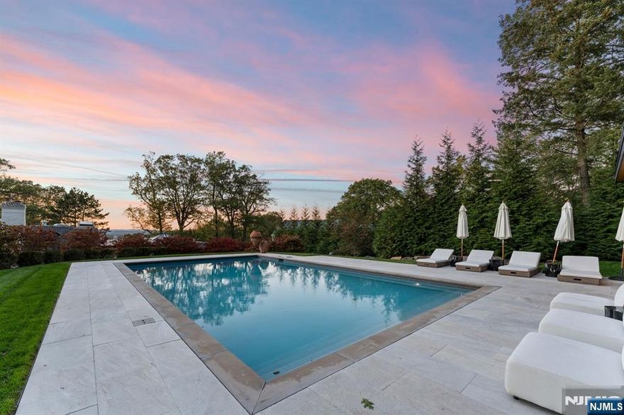 Escape to this private estate surrounded by nature and refined luxury. Set high on nearly an acre of exquisitely landscaped grounds bordering the Tenafly Nature Center, this residence offers unmatched privacy and scenic beauty. A true sanctuary, it features cascading waterfalls, a koi pond, lush gardens, and multiple stone terraces for relaxation and entertaining. At its heart, a new pool house with wet bar and bath overlooks the sparkling pool, outdoor fireplace, and expansive sitting areasâ€”creating a resort-caliber experience rarely found in Tenafly. Inside, timeless craftsmanship defines light-filled spaces including a gracious living room with fireplace, formal dining room, inviting family room, and gourmet kosher kitchen with custom cabinetry and professional appliances. The serene primary suite with spa bath is joined by five bedrooms, three full baths, a home theater, gym, and wine cellar. With slate roof, four-car garage, generator, and premier location, this estate epitomizes elegant modern living.