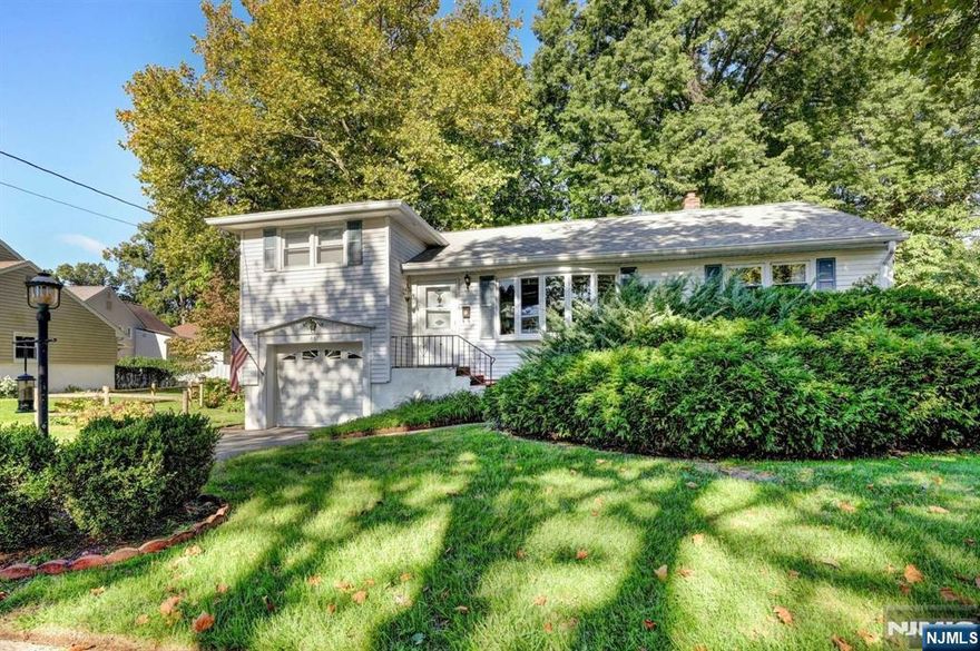 Delightful authentic Mid-Century Modern 3 BR Split Ranch offered by original owner. Highly coveted residential neighborhood. Gorgeous level property. Charming split rail fence surrounds an oasis of mature evergreen, hydrangea, wisteria, roses, dogwood, catalpa, maple & a 66 year old pin oak. Large sun-flooded LR with bay window adjoins the DR. Original oak flooring under carpeting. The Dine-In Kitchen (w/double DeLonghi wall oven, 4 burner gas range, DW, original mid-century Boomerang pattern Formica counters, and 14 large cabinets) opens to an expansive deck with custom awning. Two main floor corner BRs & updated Bathroom. Upstairs offers a large Primary BR w/PR. Lower Level has Wood Paneled FR, and Laundry/Utility Area. Superb storage throughout. Newer CAC, updated windows, Stand-by Onan 20 W Generator, and Irrigation System. Fabulous location close to school, athletic field and Gritman Park. 1 mile to downtown Westwood shops, restaurant, & train, and .25 mile to NYC bus.