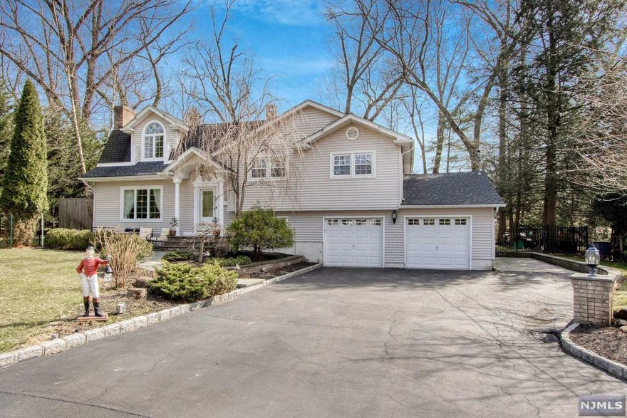 Beautifully expanded home with open floor plan in great location of Woodcliff Lake! Spacious formal living room featuring wood-burning fireplace and French doors into open dining room and great room with vaulted ceiling, fireplace and French doors to backyard. Immaculate eat-in kitchen including vaulted ceiling, white cabinets, granite countertops and ample windows for natural light. Second level offers three spacious bedrooms and an updated full bath. Third level offers a large primary suite including vaulted ceiling, walk-in-closet and updated full bath. Ground level includes a spacious family room, laundry room/half bath and garage access. Lush, professionally landscaped property including paver patio in front and fenced-in backyard with paver patio. 2-car attached garage. Close to train! You will absolutely LOVE living here!