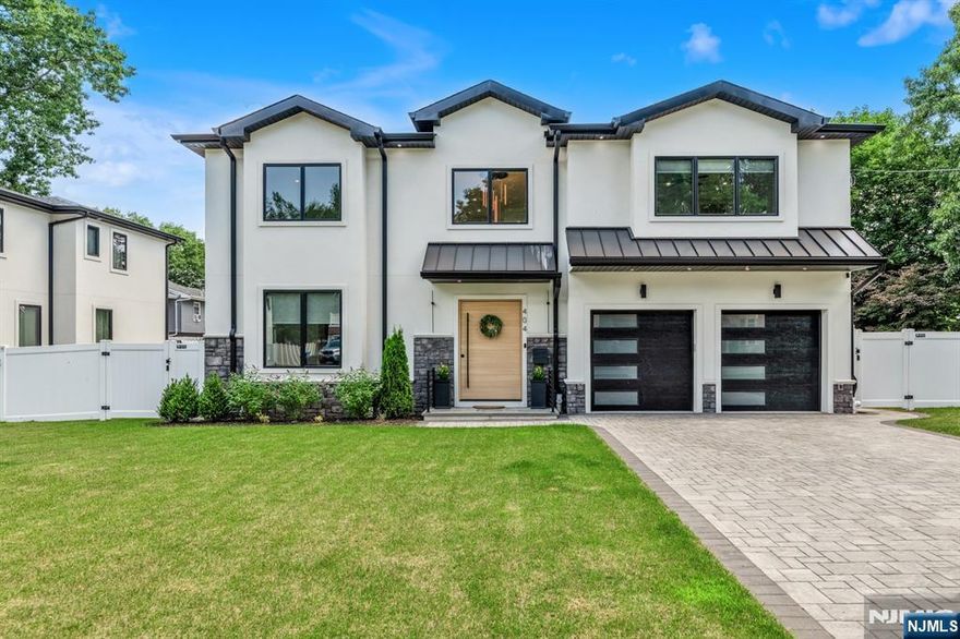 Less than a year old, this new construction home offers luxurious living on the highly desirable East Side of Paramus. With over 6,000 sq ft of finished space, this stunning residence features 6 bedrooms and 5.5 bathrooms. Enter through a grand 2-story foyer into an open-concept layout with formal living and dining rooms, a soaring 2-story great room, and intricate moldings throughout. The designer kitchen boasts quartz countertops, a large waterfall island, and top-of-the-line Sub-Zero and Wolf appliances. The main level includes a bedroom with en-suite bath, mudroom, powder room, and access to a spacious deck perfect for entertaining. Upstairs, retreat to the luxurious primary suite with a custom walk-in closet and spa-inspired bath. This level also offers a junior suite with private bath, two additional bedrooms, a shared full bath, and a convenient laundry room. The fully finished basement features a home theater, expansive rec room with wet bar, full bedroom and bath, and walkout access to the backyard. Additional highlights include a 2-car garage, paver driveway, and a large fenced backyard with paver patio. Located near top-rated schools, premier shopping, and with easy access to NYC and major highways, this home truly has it all.