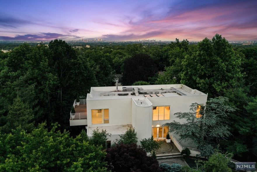 Beautiful views of New York City from this magnificent home perched on Montclair's First Mountain. Stunning, fully renovated Contemporary sets the hippest stage for everything you crave for today's lifestyle. Bright, spacious and inviting, you'll swoon for the expansive, wrap-around deck, soaring ten feet plus ceilings, skylights and welcoming, open floor plan with plenty of space for privacy. Custom built in 1991, this crisp modern home was fully renovated, creating the perfect combination of indulgence and practicality. New baths and windows, Gaggenau appliances, custom cabinetry. Primary Suite, three additional bedrooms (one could be rec room), baths, sitting room, plus family room on entry floor. Living and dining upstairs via traditional or circular staircases. Finished lower level with exercise room, laundry room, game room, and access to two-car garage.