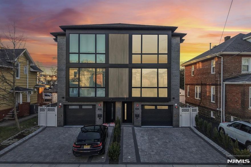 Experience the pinnacle of urban luxury in this masterfully designed four-story townhome with a private elevator and breathtaking floating staircase. This residence offers a sanctuary of style and substance, blending modern sophistication with comfort. The main living level features a spacious open-concept living and dining area with a tile-wrapped fireplace/media zone and oversized sun-filled windows. At the center is a chefâ€™s kitchen with an impressive 11-foot Quartz waterfall island, professional-grade appliances, and a beverage chiller, perfect for entertaining and daily living. This level also includes a powder room and a balcony. The bedroom level is dedicated to relaxation, offering a luxe primary suite with multiple closets, hidden storage, and a spa-like en-suite bath with multiple shower heads and heated floors. Two additional bedrooms, a beautifully designed bathroom, and a convenient laundry tower complete this level. The top floor serves as an entertainment hub with a bonus room, wet bar, and large deck showcasing NYC skyline views. The ground floor offers flexible living with a large bonus space, full bathroom, radiant-heated floors, and plumbing for a kitchenette, ideal for a gym, playroom, or multi-generational living. Sliding doors lead to a patio and fenced yard. A heated, EV-ready garage completes the home. Located near Anderson Ave and NJ Transit, this 3,150 sq ft home delivers luxury, smart features, and convenience. 2025 tax $23,460 disregard all other