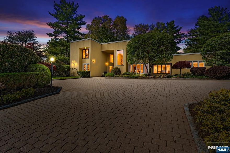 A rare opportunity to own a distinctive Livingston luxury home w/ architectural presence, resort-style grounds, & exceptional entertaining spaces that make everyday living feel special. This striking Contemporary is defined by dramatic scale, modernist lines, oversized windows & seamless indoor-outdoor living. Designed w/ intention & rooted in the history of Livingston itself, the home feels both impressive & deeply personal. Soaring spaces & natural light create an atmosphere that is grand, yet inviting. Enter the Marble Foyer & unforgettable Two-story Great Rm, where skylights pour in sunlight & walls of glass frame the private grounds beyond. A Fireplace anchors the space, while a Wet bar & dual French doors invite effortless entertaining that flows naturally out to the patio. The layout was made for gathering. The formal Dining Rm centers around a temperature/humidity-controlled glass Wine Wall that adds drama & warmth. At the heart of the home, a beautifully designed Chef's Kitchen w/ over $300k in upgrades features Viking Tuscany range, Sub-Zero refrigeration & custom cabinetry, flowing into the adjacent Family Room w/ direct patio access. Outside, enjoy a private, serene backyard w/ heated pool, expansive patio & mature landscaping. Upstairs, a dramatic gallery connects the bedrooms & overlooks the great room below. The finished basement offers Rec space & Guest/Au pair suite. Here's your rare chance to become part of the story of Livingston's truly special residences.