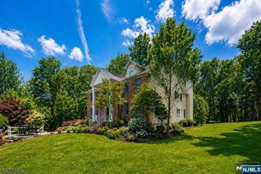 Welcome to a stately, classic Colonial set on a private, park-like setting near Union Hill Farms. Nestled on nearly 2 acres of property & backing to 8 acres of protected, town owned wooded land, this home offers exceptional privacy, serene surroundings & timeless curb appeal. A sweeping approach from Cooper Rd/Druid Hill which allows for privacy, leads to this impressive 4 BDRM, 3.5 bath residence offering over 5,600 sqft of living space. Built by the original Cedar Gate contractor, the home showcases quality craftsmanship & a commanding presence. A grand 2 story foyer sets the tone, opening to a bright, open concept layout ideal for both everyday living & upscale entertaining. The gourmet chef's kitchen features a large center island, butler's pantry with sink & sunlit breakfast area, seamlessly flowing into the expansive family room. Additional standout spaces include a sun drenched conservatory, perfect for a billiards room or lounge & a private 2nd floor office. The luxurious primary is a true retreat, complete with an oversized sitting room with fireplace & a spa-like ensuite bath. Step outside to the expansive deck, ideal for entertaining or enjoying peaceful sunrises & sunsets surrounded by nature. Full basement with endless potential, attached 3 car garage & close proximity to DWTN Denville, Union Square shopping, Morristown Green & NYC direct train access. This one-of-a-kind luxury home offers the perfect blend of privacy & convenience in the heart of Morris County.