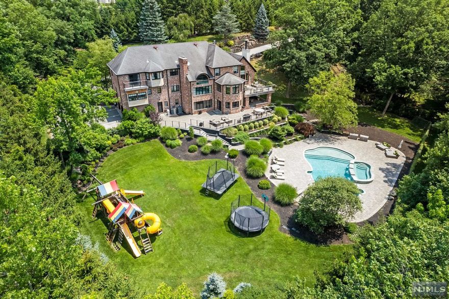 Sensational renovation! Meticulously maintained bright modern-colonial sun drenched Southern exposure towering over 2.3 well landscaped, gated acres with a free-form pool and large spa. Multiple deck and patio areas for grand scale outdoor entertaining. Two primary bedroom suites on both the first and second level. Four additional bedrooms. Two-story living room with fireplace, one and half-story family room with fireplace. Huge kitchen with breakfast area and dining room with recessed ceiling. Library and separate office on the main level. Lower level is grade access with the rear yard and features a large entertainment area, family room with fireplace, second kitchen, bedroom and two full baths. Elevator to all levels, 3 car garage, generator. Cassandra Drive is one of the few streets in Alpine where every lot is well over 2 acres ensuring maximum privacy.