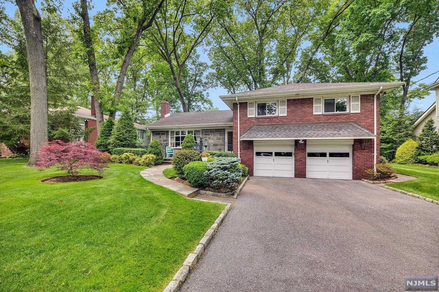Nestled at the crest of one of Fair Lawn's PREMIER streets, this GRACIOUS STONE & BRICK home offers a wonderful lifestyle. Enjoy a leisurely cup of Joe or evening glass of wine on the wide front porch while admiring the quiet beauty of your surroundings. The bright spacious living room w/wood-burning fireplace opens to a large DR overlooking the LEVEL PARK-LIKE FENCED YARD. A cheery updated eat-in kitchen with light wood cabinets & double oven leads to the large paver patio. Ascend to the roomy upstairs level which boasts hardwood floors and 3 generous bedrooms including primary BR w/lovely ensuite bath & double closets. The walk-up attic provides abundant storage or potential for future expansion. Relax in the tiled family room w/convenient entrance to ATTACHED 2-CAR garage. Basement offers a finished rec room with high ceilings, half bath, WIC & laundry. MILNES school district & just minutes to NYC transit, Berdan Grove Park & downtown shopping/restaurants! Underground sprinkler