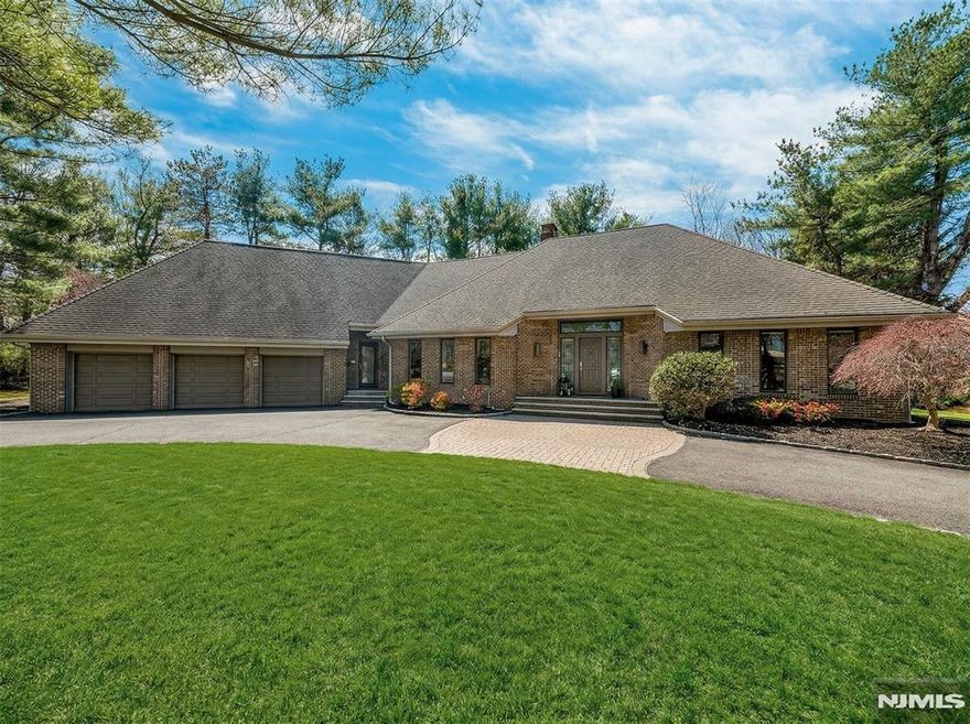 Expansive contemporary residence set on a tranquil cul-de-sac in ultra-desirable Franklin Lakes, located within Walder Estates. This impressive home offers 5 bedrooms, 3 full bathrooms, & 2 half bathrooms. Situated on a professionally landscaped 1-acre lot with a grand circular driveway, the property seamlessly blends modern elegance with exceptional privacy. A stately all-brick exterior provides timeless curb appeal. Inside, a dramatic two-story foyer opens to a sun-filled great room with soaring ceilings and a wall of windows overlooking the lush property, creating a seamless indoor-outdoor connection. A two-sided fireplace elegantly anchors both the great room & the adjacent living room, while the open-concept layout is ideal for both everyday living and entertaining. The 1st floor primary suite offers the convenience of main-level living. Thoughtfully updated and well maintained, the home features a 2019 renovation including new hardwood flooring throughout & multiple recent system and appliance upgrades. Beautifully maintained grounds feature mature landscaping, a large patio, and an outdoor kitchen plus a full irrigation system. A large unfinished basement offers excellent potential for future expansion or customization. Truly move-in ready, this home offers quality construction, thoughtful updates, and an exceptional location near top-rated schools, premier shopping, parks, & nature. Conveniently located just 30 minutes from NYC, with low Franklin Lakes property taxes.