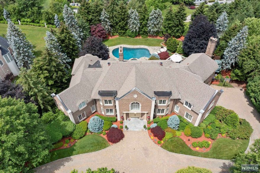 MAJESTIC COLONIAL LUXURY ESTATE WITH 18 ROOMS! ACCENTUATED W/THE MOST BEAUTIFULLY LANDSCAPED GATED PROPERTY WHICH OVERLOOKS THE BREATHTAKING RAMAPO MOUNTAINS. THE STUNNING MARBLE FOYER LEADS TO 2 FORMAL LIVING RMS, FORMAL DINING RM, GRAND GREAT RM, GOURMET KITCHEN W/BREAKFAST AREA WALKS OUT TO THE GRAND TERRACE, ADDITIONAL MASTER BEDRM SUITE, BEDRM & BATH/GYM, LIBRARY/OFFICE, 2 POWDER ROOMS, BONUS: ELEVATOR TO ALL FLOORS. MARBLE, HARDWOOD, RADIANT FLOORS, CUSTOM MOLDINGS, FULL CRESTRON SYSTEM & SECURITY CAMERAS THROUGHOUT. THE SECOND FLOOR FEATURES A GRAND MASTER BEDROOM SUITE W/SITTING RM, FIREPLACE & 3 ADDITIONAL EN SUITE BEDROOMS. LOWER LEVEL FEATURES A FAMILY RM, BILLIARD ROOM W/FIREPLACE, FULL KITCHEN WITH GRANITE COUNTERS, 2 ENSUITE BEDRMS FOR AN EXTENDED FAMILY W/EXTRA LG WALK-IN CLOSETS. FRENCH DOORS WALKOUT TO THE GUNITE POOL & SPA, CUSTOM GRILLING AREA. RARE 5 CAR GARAGE..BLUE RIBBON TOP-RATED SCHOOLS. MINUTES TO THE GW BRIDGE TO MANHATTAN. VERY PRIVATE & PRESTIGE AREA!