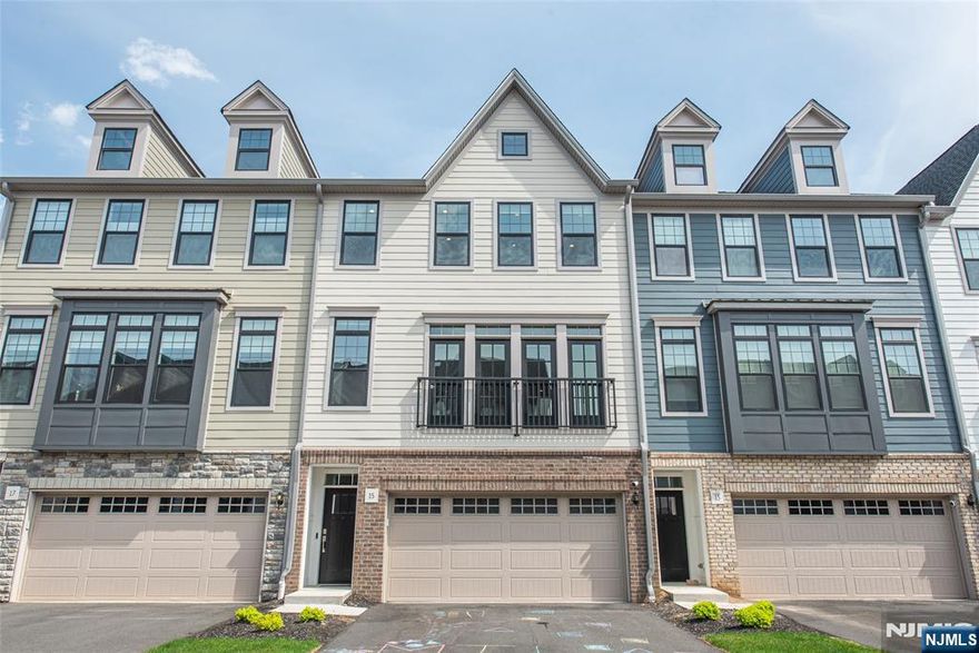 Welcome to The Grove at Upper Saddle River. This Briercliff model features extensive builder upgrades and backs to a private wooded setting. The open concept floor plan provides excellent natural lighting and is designed for both everyday living and entertaining, featuring a main-level office and a dining area with sliders to a deck. The kitchen offers a large center island, upgraded cabinetry, and full roll-out shelving for added convenience. Upstairs, the primary suite features a finished walk-in closet and a spa-like bath with a rain shower. Two additional bedrooms feature finished closets, and the hall bath includes a double sink vanity. A laundry room with added cabinetry completes the upper level. The finished lower level provides flexible living space with a recreation room that walks out to a paver patio, along with built-in shelving and space for a mini fridge. Upgrades throughout include custom hardwood flooring, iron rod railings, a stone fireplace, Sonos sound system, custom blinds, enhanced pantry shelving, and built-in garage storage. Excellent location - minutes from two train stations, bus stops, major highways, restaurants, shopping and entertainment. A perfect blend of style, function, and privacy move right in and enjoy.