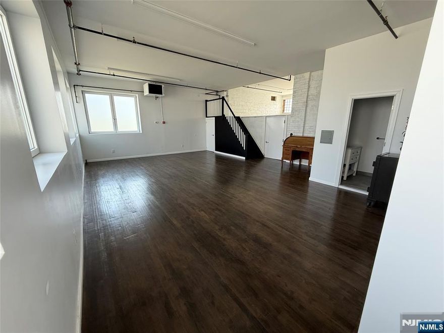 Beautifully constructed, never before used, light and bright space available for commercial lease. The large, open space allows for a versatile, custom setup to suit your business needs; office space, creative studio or small business. Oversized windows let in lots of natural light. The main space is approximately 575 sq ft (10'8" ceiling height, approximate); plus additional loft space, approximately 440 sq ft (6'4" high). New, modern, full bath with walk-in shower. Attached, single car garage included in rent with access directly into the unit. Use of coin laundry permitted if needed. Located one block from Passaic Street with bus stops and major shopping centers; approximately 0.5 mile from train station and close proximity to major highways. Gross lease, tenant pays monthly gas and electric. Business type dependent on town approval.