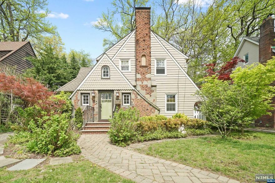 Discover a rare treasure nestled in the sought-after Manor district, on a picturesque tree-lined street. This timeless Tudor presents 3 bedrooms and 2 meticulously updated full baths. The crown jewel of this home is its gourmet kitchen, boasting granite countertops, a spacious center island, and top-of-the-line stainless steel appliances. Step outside to the inviting blue stone patio, perfect for seamless barbecue gatherings and outdoor festivities. Additional luxuries include a fully finished attic, a walkout basement, complete with full bath, laundry, ample storage and a sizable closet. The basement offers versatile living options as potential 4th bedroom. Notice the original charm, showcased through the beautiful, wood moldings and gleaming hardwood floors. . Completing the package are the cobblestone driveway, and a detached two-car garage. Convenient to downtown shops, Parks and NYC Trans. Don't miss!