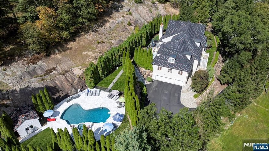 Discover an extraordinary estate featuring a FIRST FLOOR PRIMARY SUITE redefining luxury in Sparta's most coveted enclave situated in the highly sought-after Sawmill Estates neighborhood located just 1 HOUR TO NYC! Nestled on 3.71 acres, 49 Cherokee Court is a 7,600+ Square Foot residence blending classic grandeur with modern refinement. Upon entry you are greeted by a Soaring Two-Story Foyer grand entrance making a stunning first impression. The main level features a Cathedral Ceiling Living Room with overlooking balconies anchored by a stately Fireplace, a Family Room accented by ceiling wooden-beams, elegant Formal Dining Room & Formal Family Room/Office space. The gourmet Eat-In Kitchen is a Chef's delight highlighted by Top-Of-The-Line Appliances, custom-milled Cabinetry & Center Island with Breakfast Bar. The First Floor Primary Suite features a BONUS Adjoining Suite with cozy Fireplace, Walk-In Closet & En-Suite Bathroom including a Dual Vanity Sink, Stall Shower & jetted Soaking Tub. Upstairs you will find 5 spacious Bedrooms with 3 En-Suite Bathrooms completing the space. This Private Oasis getaway is an Entertainers Paradise offering a STUNNING Heated In-Ground Gunite Pool with built-in Hot Tub and gorgeous Marble hardscape surrounded by lush landscaping & a wooded backdrop. Sparta offers the #1 School District in Sussex County. Nearby highly desired attractions Lake Mohawk in Sparta, Lake Hopatcong & Year-Round Resorts Crystal Springs, Minerals & Mountain Creek.