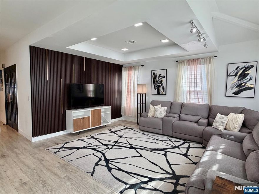 Only 3 years young, this exceptional 4-bedroom, 3-bath residence offers a rare opportunity to own a modern home with high-end finishes and timeless design throughout. The home features a bright open-concept layout with soaring ceilings and a striking modern staircase set beneath a dramatic double-height ceiling with a statement chandelier. The gourmet kitchen is designed to impress, showcasing quartz countertops, premium stainless-steel appliances, a custom glass-door pantry with illuminated shelving, and a sleek bar with a wine coolerâ€”seamlessly flowing into the living and dining areas for effortless entertaining. The first floor offers a spacious bedroom and full bath, ideal for guests or flexible living. Sliding glass doors from the dining area open to a large deck overlooking a private backyard, creating a seamless indoor-outdoor lifestyle. Upstairs, the primary suite is a true retreat with vaulted ceilings, two walk-in closets, and a spa-inspired bathroom. Two additional bedrooms, complemented by a private balcony, and a cozy office nook in a whole way. Additional highlights include a full basement with laundry and abundant storage, as well as a detached two-car garage. Ideally located in Little Falls, just minutes from NYC-bound train and bus service, top-rated schools, parks, and local cafes. A true turnkey residence offering style, comfort, and convenience from day one.