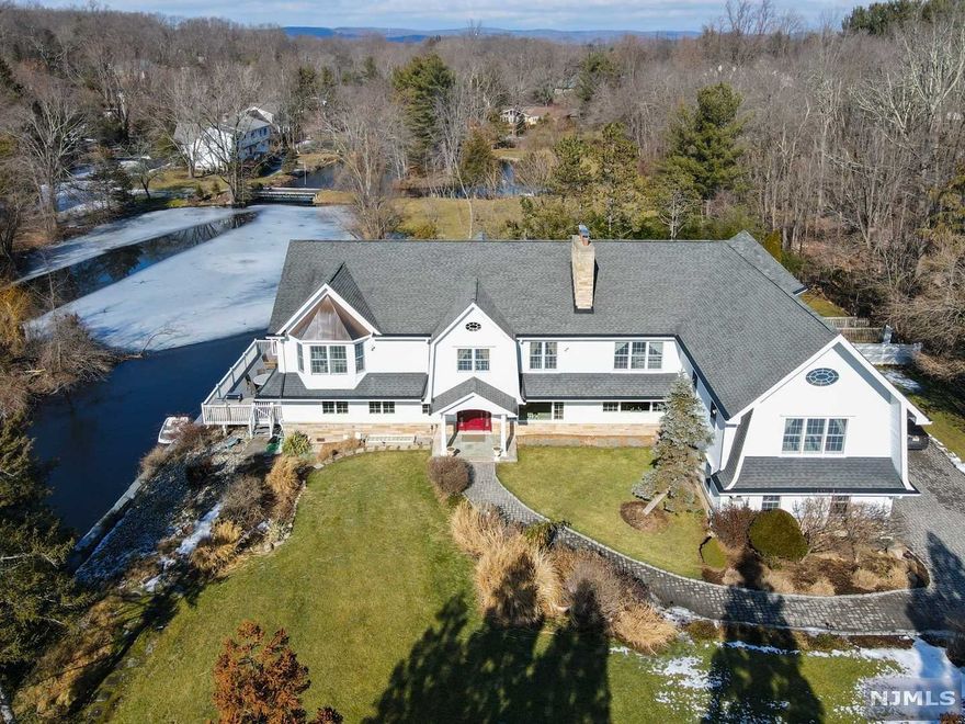 Welcome home to this fabulous 6,500sf Franklin Lakes gem. This one-of-a-kind home offers two separate master suite wings with their own study, spa-like baths and walk in closets. The main level has a beautiful flow providing an extra-large open kitchen with top-of-the-line appliances, double sinks, center island and breakfast peninsula. A super bright living room opens to a deck with outdoor kitchen that overlooks the lake. For pet lovers, there is a custom-built pet bathroom on this level, with a walk-in dog shower. A finished basement offers a summer kitchen, another fireplace, plenty of space to entertain or set up a home gym, movie theater etc. A resort-like back yard boasts a 6ft deep swimming pool, another bar area and patio, as well as access to the lake where you can paddle boat and fish. Located just half hour outside of NYC and close to everything Franklin Lakes has to offer including the Indian Trail Club and restaurants, this home is not to be missed.