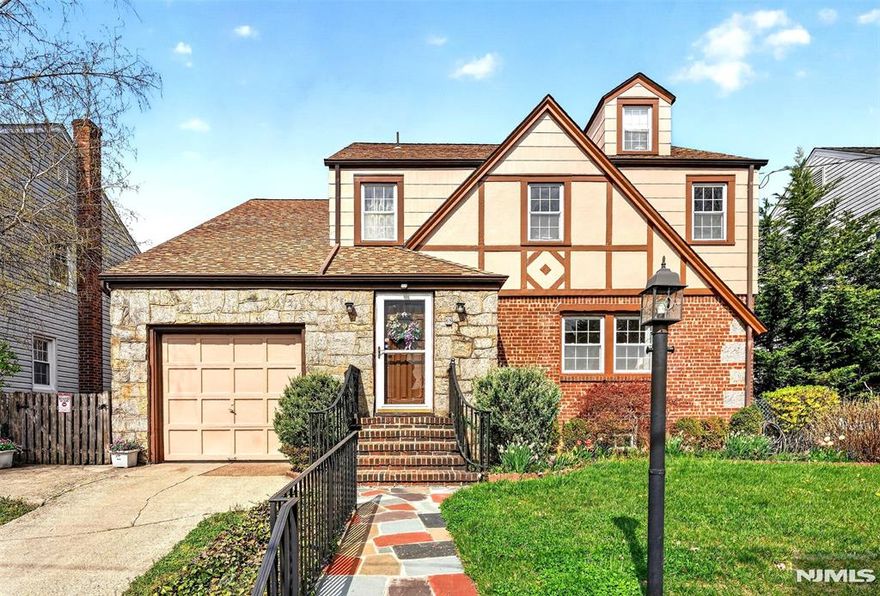 Step into timeless charm with this meticulously maintained Tudor-style home. A welcoming foyer sets the tone as you enter, leading into a spacious living room featuring a detailed fireplace, beautiful stained glass panels, and rich hardwood floors that carry throughout. The layout flows effortlessly into a large dining room highlighted by elegant bay windows before opening into an eat-in kitchen. Just beyond, youâ€™ll find a versatile bonus space complete with a full bathroom, abundant storage, and a three season room that leads out to the backyard. Outside, a polished outdoor space awaits with both a deck and grassy area, ideal for entertaining or relaxing. Upstairs offers three generously sized bedrooms and a full bathroom, including a spacious primary bedroom with an additional adjoining roomâ€”an ideal opportunity to create the primary suite of your dreams. A walk-up attic provides even more potential and storage options. A finished basement with a dedicated laundry area completes this space offering both functionality and flexibility. A rare blend of character, space, and potential located just minutes to the main street and bus transportation!