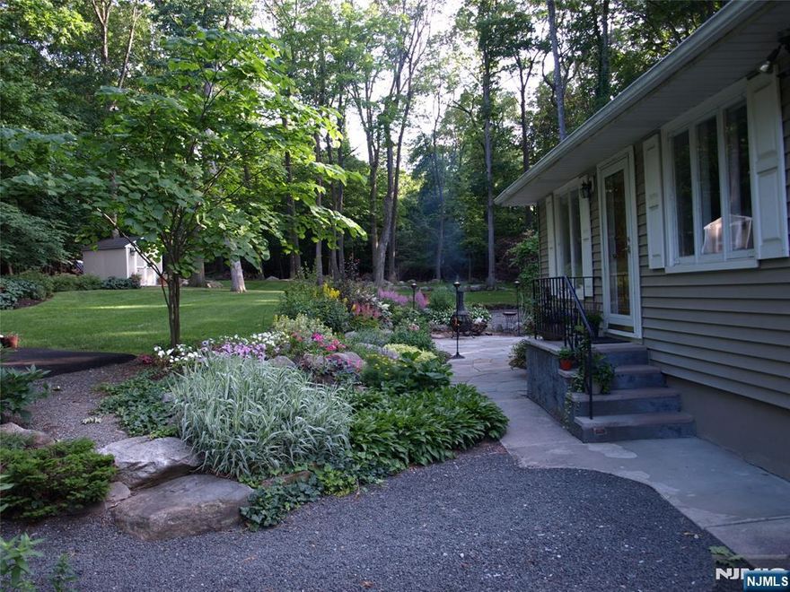 Hidden paradise best describes this home on a double, separate-deed lot measuring 120x240 in total featuring blue stone patios, a built-in stone barbecue grill, a waterfall, and pond. Beautifully maintained, the kitchen includes newer cherry cabinets, granite tops, and new appliances. The living room is warm and inviting with hardwood floors throughout and a wood-burning fireplace. The full bath is also recently updated, with Wane's coating and a large linen closet. The fully finished walkout basement features built-ins, a wet bar, a recreation room with a gas fireplace, an office or den, and a laundry room. Half of the one-car garage has been converted into an office, but can easily be changed back. ATTENTION BUILDERS: Buy and build a house on the adjacent lot. Outdoor pictures are to show the patio and grounds; some plants have been removed. The required Lake Association fee is $70.00 per year. Access to Lake