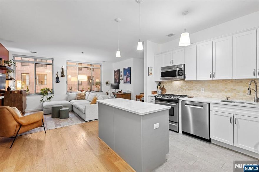 Beautiful south-facing 2 bedroom, 2 bathroom condo in Hamilton Park. his recently renovated home offers 1,322 sq. ft. of luxurious living space, with oversized windows in every room, flooring and a kitchen updated in 2023. The open-concept living area is bright and spacious, offering plenty of room for both living and dining areas. The modern kitchen features Calacatta quartz countertops, tiled backsplash, stainless steel appliances, an undermount sink, a large center island, and gray-and-white shaker cabinetry. The spacious primary bedroom features an ensuite bathroom with radiant heated floors and dual closets, including a large walk-in closet, and a generously sized second bedroom. The home also offers a newer in-unit washer/dryer, central air conditioning, separate private storage, and generous closet space. Hamilton Square is ideally located across from Hamilton Park and offers a full-service lifestyle with a 24-hour concierge, resident street parking, storage units, and access to a health club with pool available to residents at a reduced membership fee. The building also features a massive rooftop terrace with outdoor grills and sweeping views of New York City and New York Harbor. Cafés, shops, and restaurants are conveniently located on the premises and throughout the surrounding neighborhood. Nearby garage parking is also available for a fee. Gas and hot water are included in the HOA fee, and the property benefits from a tax abatement in place through 2033.