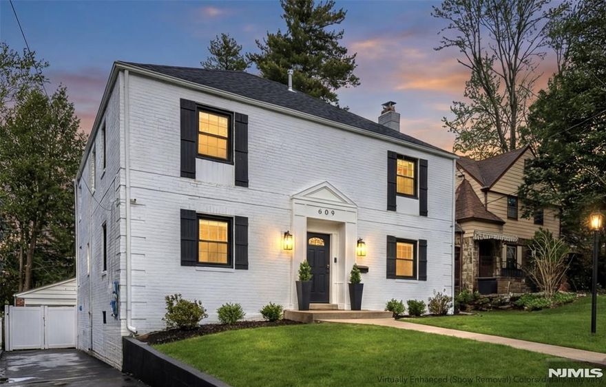 Beautifully updated 5-bedroom, 3.5-bath Center Hall Colonial down the block from the park offering great space, modern upgrades and indoor-outdoor flow. The home welcomes you with a classic entry foyer leading to a spacious living room with wood-burning fireplace, formal dining room off the kitchen, an elegant powder room with custom millwork and a sun-filled family room with brick and wood beam ceiling. Both the kitchen and sun room open to the deck ideal for entertaining. The eat-in kitchen includes quartz counters, marble backsplash, two farmhouse sinks, two ovens, microwave, dishwasher, wine fridge, 7 ft center island with seating for six plus breakfast area. The second floor offers four bedrooms including a primary suite with a private bath, additional full bathroom with double vanity, and large landing with access to 2nd-floor deck. The finished basement includes guest/in-law suite with large bedroom, custom closet and full bathroom plus recreation/playroom, bar, laundry and large utility room. The fenced backyard features a deck, patio, play space, tall privacy trees, and fenced basketball area. Other highlights include 2-zone central HVAC, Tesla EV charger, smart thermostat, exterior security cameras, oversized garage and long driveway. On a quiet tree-lined street just down the block from the park, playground and dog park with easy access to transportation, Route 4 and houses of worship. Text/call owner directly 347-446-0567. Owner holds NJ RE license.