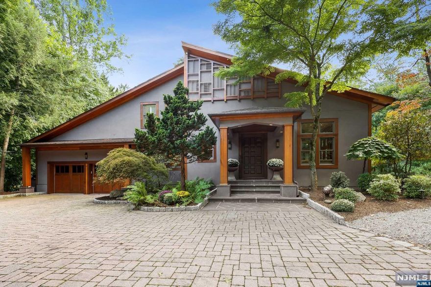 Set far off the road is this private retreat nestled among 1.6 ac of lush property. The 2-car wide circular paver driveway takes you to an impressive covered front porch,where you are able to appreciate the artisan hand applied cement stucco exterior, trimmed in solid Mahogany. Inside, you'll be delighted by the open floor plan of this 4 BR, 4.5 BA home designed for easy living. Attention was paid to exceptional detail beginning with a noted Salerno gourmet kitchen complete with an array of high end appliances incl. ice machine, refrigerator drawers, wine refrig and more. The sizeable Primary BR features a coffered ceiling, huge organized closet and a hotel inspired Bath w Radiant Heat, steam shower and soaking tub.The finished basement has large windows allowing much daylight for a rec room, BR, FB, Gym and tons of storage. The custom Mahogany porch will beckon you to watch the surrounding trees go through their changes year after year. New septic In October.