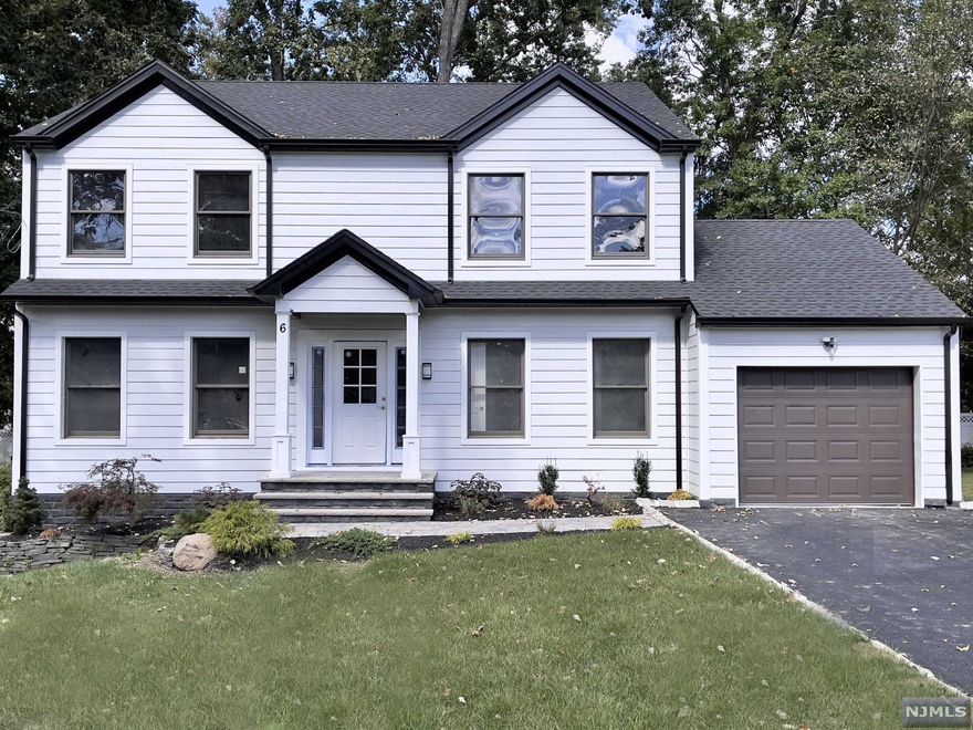 COMPLETE RENOVATION by RODAK BUILDERS. This classic center hall Colonial on a quiet wide street features HW floors throughout, custom millwork & stylish white Hardie front siding & dark windows. The home is complete w 5 bedrooms & 3.2 baths & includes a Formal LR that opens to a spacious FR w electric FP w brick surround & sliders to a large maintenance free Trex deck leading to a private level lot & gourmet KItchen w SS appliances, center island, ceiling height cabinets, 1st floor en-suite, mudroom & powder room. The 2nd floor is home to the master suite w walk in closet, 3 additional spacious bedrooms, main bath & laundry. Full finished basement w 10' high ceilings, laminate flooring, storage area & half bath. Walking distance to houses of worship, schools & NYC bus.