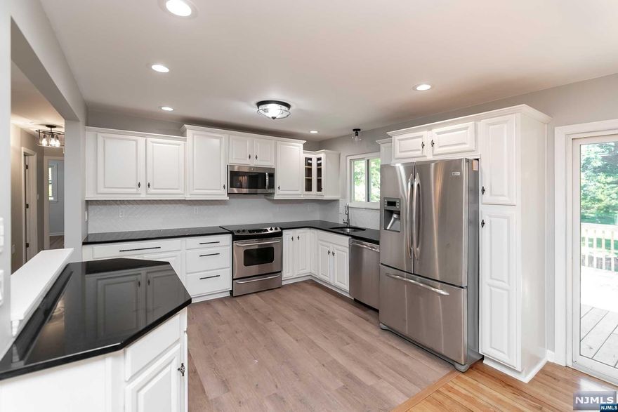 JUST RENOVATED! MODERN & BEAUTIFUL! Fabulous location on OVER 1.4 ACRE LOT! Desirable BI-LEVEL style home with many updates features newer Appliances, Updated Kitchen with open floor plan, granite counters, neutral colors, beautiful backsplash with under cabinet lighting, STUNNING BATHROOMS! high end features include, in-shower LED lighting, expert tile work, and modern vanities. New flooring in most areas and hardwood refinished. Spacious ground level walk lower level with Attached garage, Lower level family room with new electric insert fireplace. Brand New Deck overlooking private yard (Mostly fenced in.) Ideal for entertaining. Convenient to shopping and local conveniences. Property deed indicates 2 lots. Hurry wont last! Agent Remarks: Driveway and fence being sold as is. Newly installed electric fireplace and heatpump/ac unit for lower level is supplemental to house central a/c unit for upper floor.