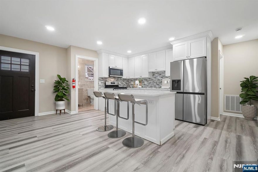 Newly renovated two family home. Apartment 1 features a complete remodel showcasing an Open Entertaining floorplan. Kitchen with Granite Counters, Expansive Center Island, deco tiled backsplash, SS Appliances, deco lighting. Luxury vinyl flooring throughout. Brand new full baths, entertaining family room with a surround of windows. Primary bedroom complete with luxury vinyl flooring; brand new full bath, Laundry. 2nd Bedroom with nice size closets and luxury vinyl flooring. Spacious, sun filled, open entertaining floorplan. Central heating / air throughout. Use of expansive rear yard. Parking for one car. Prime location! Walking distance to Schools, delightful parks, NYC trains & transportation. Unique opportunity not to be missed. Ready for immediate move-in!