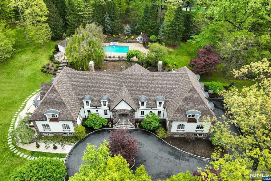 A bucolic oasis only 6 miles from the GWB, this enchanting estate is surrounded by 3.16 acres in Old Smith Village in Tenafly. Nestled at the end of a sought-after cul-de-sac, this turn-key home exudes elegance and luxury. Recently renovated, the main residence features extraordinary architectural detailing combined w/modern high-end finishes. The grand entry foyer leads to beautifully proportioned reception rooms including a stunning gourmet chef's kitchen. From nearly every principle room there is access to the grounds. There are 2 primary suites, one on the main level and one on the second level. Several home office and play/rec room options on both the lower and upper level of the home. The grounds offer sweeping lawns, flowering trees, stone terraces and pathways. Intimate outdoor dining area, swimming pool w/state of the art salt water purifier, full service cabana and sundeck. 4 car garage. Numerous interior and exterior enhancements including new roof!