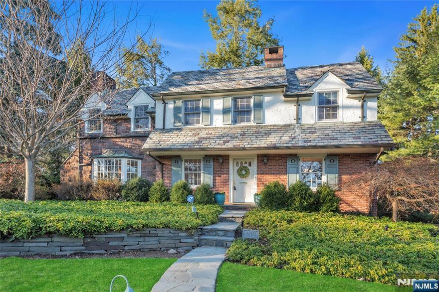 This stunning Ridgewood home combines timeless charm and elegance, just minutes from the vibrant Village of Ridgewood. The Colonial exterior, w/ brick, stone & a classic slate roof, makes a striking first impression. Inside, the spacious LR w/ fireplc features French doors opening to a landscaped backyard with a serene brick patio, perfect for entertaining. A formal DR offers an elegant space for gatherings. The chef's kitchen flows into a bright breakfast area and expansive Great Room w/ soaring cathedral ceilings, grand Palladian window & French doors leading outside. The 1st floor also includes a convenient PR. Upstairs, the primary suite includes a marble bath & dressing area, while 3 additional corner bedrooms share a well-appointed hall bath. The finished basement offers a playroom, laundry room, garage access & ample storage. With its prime location near schools, shopping, and NYC transit, this sunlit home offers convenience & elegance, making it a must-see in Ridgewood!
