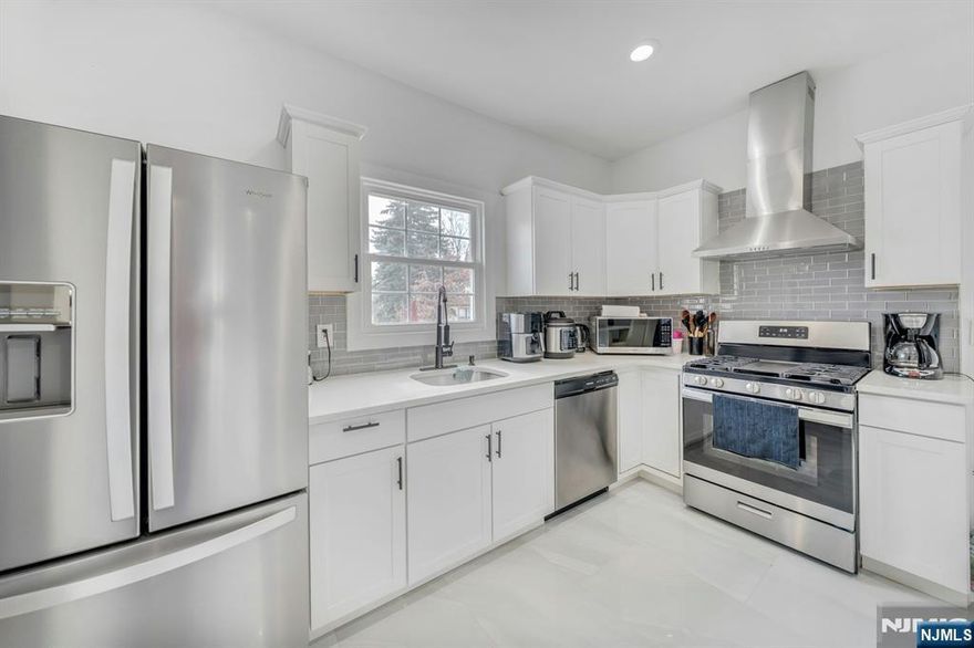 Situated on a quiet, tree-lined street, 106 Paine Ave is a beautifully maintained Colonial-style home that perfectly blends classic architectural charm with modern, move-in-ready convenience. This spacious one-family residence features a bright, open layout, highlighted by gleaming hardwood floors and an abundance of natural light. The heart of the home is the updated eat-in kitchen, which boasts sleek white cabinetry, a stylish tiled backsplash, and premium stainless steel appliances, all anchored by a functional breakfast bar and a generous pantry. Designed for modern living, the home is equipped with central air conditioning and multi-zone heating to ensure year-round comfort. The second level serves as a private sanctuary, housing three comfortable bedrooms and a full bath, while the main floor includes a convenient laundry area with a stackable washer and dryer. Beyond the primary living spaces, the walk-out basement offers immense potential for a home gym, workshop, or additional storage with easy ground-level access. Outside, the property features a dedicated driveway with parking for multiple vehicles. Ideally located in a highly walkable neighborhood, this home puts you just minutes away from local schools, shopping, and major commuter routes, offering the perfect balance of suburban tranquility and urban accessibility.