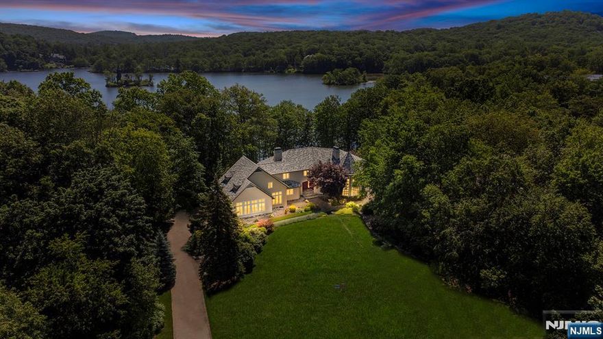 Indulge in lakeside luxury as this exceptional residence sits just 35 miles from Manhattan and offers one of NJ's most exclusive waterfront experiences. Located on famed West Shore Dr in Smoke Rise, Kinnelon's renowned gated community, this residence provides an ever-evolving panorama of stunning lake views visible from nearly every room. Live every day like a tranquil getaway, as the home boasts a sprawling waterside pool area complete with patios, an outdoor kitchen, and gated access to lake/trails. Inside, soaring ceilings and walls of glass highlight the expansive floor plan, offering exquisite living areas over three floors. Within this sought-after gated enclave, you'll find one of New Jersey's liveliest social scenes, with an array of clubs, dining, a beach, tennis club, sports bar, fishing, swimming, 24/7 gated security, and more. Embrace this exceptional opportunity to own a breathtaking home in an unparalleled setting! Schedule your private tour today.