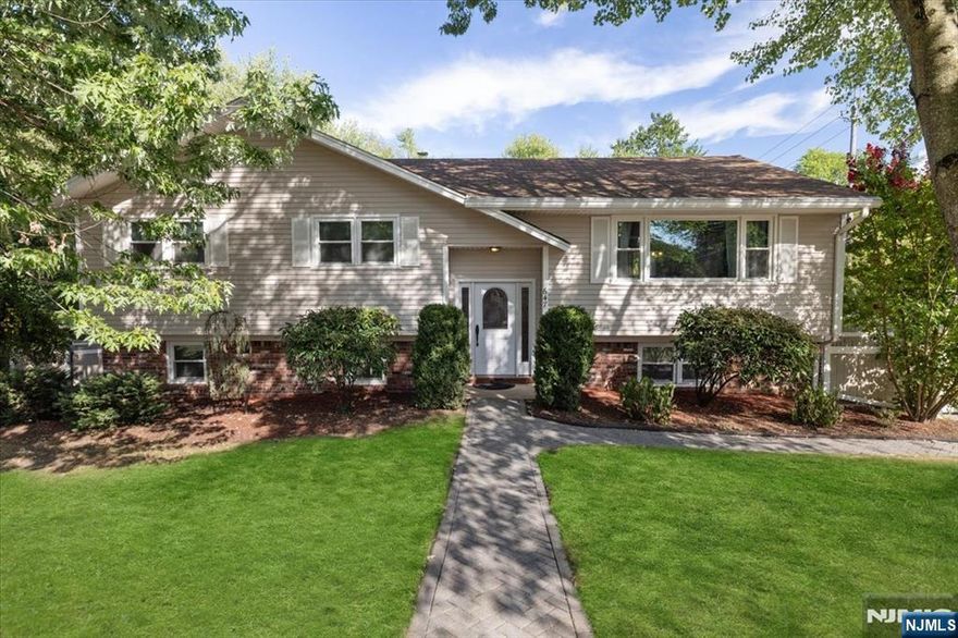 Discover the epitome of pride in homeownership with this meticulously maintained residence that truly has it all. Step into a welcoming foyer that leads to an expansive first floor, featuring a spacious living room and a dining room with elegant patio doors opening to a generous, beautifully designed patioâ€”perfect for entertaining or relaxing. The updated kitchen is a chefâ€™s dream, boasting sleek stainless steel appliances, including a 36â€ range, and modern finishes. Upstairs, youâ€™ll find three well-appointed bedrooms, including a serene master suite, complemented by a stylishly updated bathroom. The ground level offers incredible versatility with a full bedroom, a cozy family room, and a second full bathroom, all with direct access to the expansive, well-manicured backyard. A separate side entrance makes this space ideal for extended family or guests. Additional highlights include a two-car garage, a large driveway, central air conditioning, and gleaming hardwood floors throughout. This home is a rare find, blending modern upgrades with timeless charm in a beautifully maintained setting