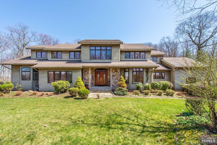 Sprawling peaceful and serene custom home! 5 BRs, 4.1 BA, 2 Car Garage plus 2 fireplaces. This exquisite home is a short drive within the Estates at Kinnelon and is set back off the street providing lots of privacy. Features include dramatic entry foyer with sweeping staircase, post & beam construction, open floor plan, natural light filled rooms, soaring ceilings, generous living spaces, hwflrs, radiant heated floors in the Kitchen and master BA, spacious EIK open to Great Room w/Walls of Windows, large eating area overlooking private back yard, first Floor Master BR suite with separate access to deck, finished walk out LL w full BA, and Expansive deck overlooking picturesque property. Perfectly designed to entertain inside & out! Natural gas. This pristine home is close to shopping, easy access to highways, near parks, less than 35 mi to NYC.
