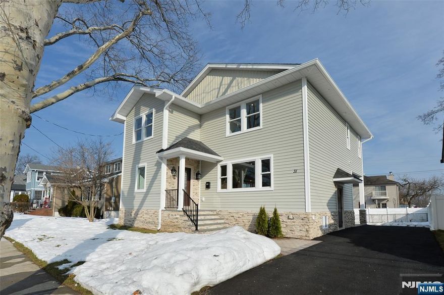 Discover elevated living in this newly constructed luxury residence built on an existing foundation, ideally located in sought-after Fair Lawn, renowned for its vibrant community, top-rated schools, beautiful parks, and effortless access to NYC. A charming entry foyer welcomes you into a bright, open-concept living space where refined design meets modern comfort. The living room is anchored by a sophisticated shiplap-encased electric fireplace with a custom TV niche, flowing seamlessly into an elegant dining area adorned with an ornamental chandelier. The stunning eat-in kitchen is truly magazine-worthy, featuring a beautifully appointed center island and a chic pantry with French bistro-inspired detailing. Backyard access and a sleek, modern powder room complete the first level. Upstairs, designer finishes define the serene primary suite, showcasing a second encased fireplace, custom TV nook, and a spa-like ensuite with designer wallpaper, soaking tub, modern glass stall shower, dual vanities, and a spacious walk-in closet. Three additional sun-drenched bedrooms and a beautifully curated full bath with dual sinks and a contemporary shower-tub combination complete this level. The fully finished basement offers exceptional versatility with a spacious recreation room, laundry area, and an additional full bath. Outside, a generously sized backyard provides the perfect setting for effortless summer entertaining.