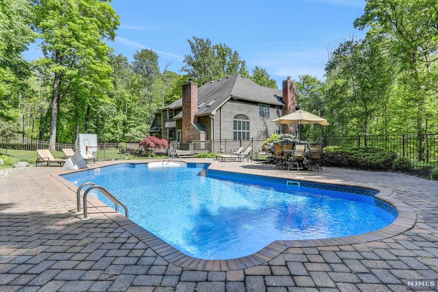 From the moment you turn into the long driveway and pull up to this STUNNING private 3.1 acre estate, this beautiful home will blow you away. Stepping inside, you're greeted by a sweeping 2-story foyer with massive windows that lead into the spacious family room, complete with fireplace, multiple skylights, and a wet bar. The chef's kitchen boasts high end appliances and looks out over the beautifully landscaped yard. The dining room opens onto the large deck, and a massive office down the hall also features sliders onto the deck. Upstairs, the primary suite, complete with private balcony, features two large walk in closets, a sitting room that can be used as an additional closet, massive bathroom with jetted tub. Two other spacious bedrooms on the second floor share a jack and jill bathroom. In the back, a large heated pool with extra patio space is nestled amongst beautiful landscaping just off the deck. this stunning private estate that leaves no box unchecked!